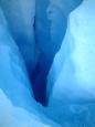 Water cascades into a deep glacier drain hole