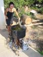 Keiko stirs a cauldron brewing a herbal wash for the insides of the barrels